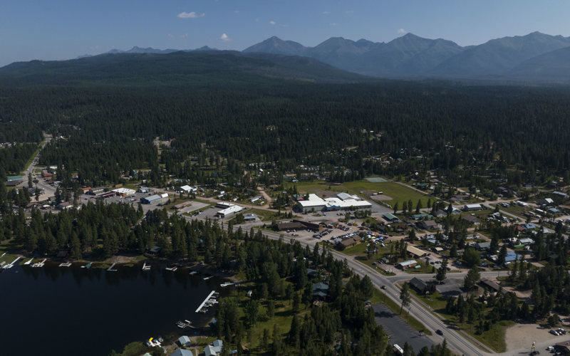 Aerial view of downtown Seeley Lake in summer with mountains in the background